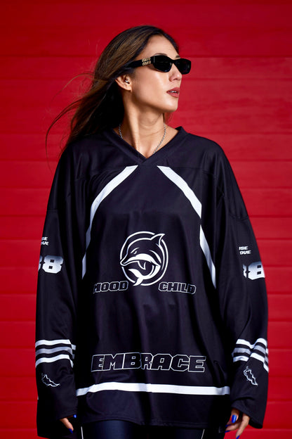 Manda Moor wearing Mood Child Mighty Daulphin black sports jersey with white text and logos against a red background